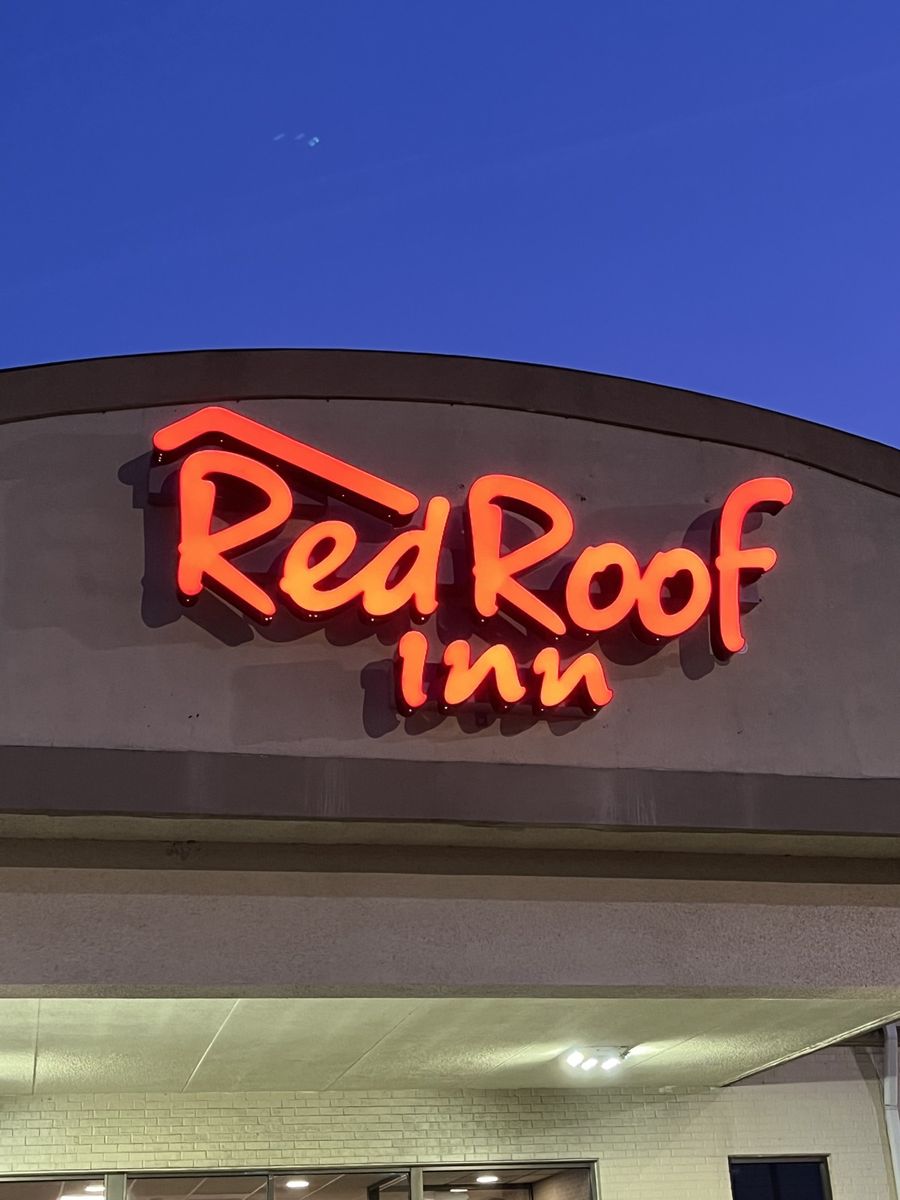 Illuminated neon script sign at dusk